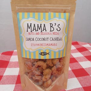 May include: A clear plastic-windowed bag of Samoa Coconut Cashews. The bag is brown with a colorful label that reads "Mama B's Nuts and Delicious Needs". The label has a blue and yellow striped background and the text "Samoa Coconut Cashews".