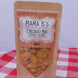 May include: A clear plastic bag filled with Chicago Mix cheddar caramel snacks. The bag has a brown paper exterior with a label that reads "Mama B's Nuts and Delicious Needs Chicago Mix Cheddar Caramel". The bag is on a red and white checkered surface.