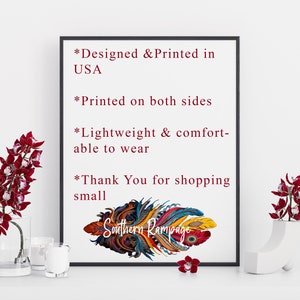 Pu&ograve; includere: Un design di piume colorato con il testo "Southern Rampage" stampato su uno sfondo bianco. Il testo "Designed & Printed in USA", "Printed on both sides", "Lightweight & comfortable to wear" e "Thank You for shopping small" &egrave; anche stampato sullo sfondo bianco.