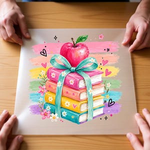 May include: A square print featuring a stack of four colorful books tied with a teal ribbon, topped with a bright red apple. The background consists of horizontal pastel brushstrokes in pink, orange, yellow, green, and purple, accented with small flowers, hearts, and sparkles.