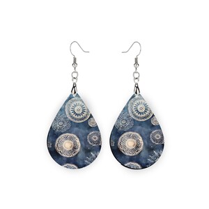 Pu&ograve; includere: Un paio di orecchini a goccia d'argento con un motivo mandala blu e bianco.