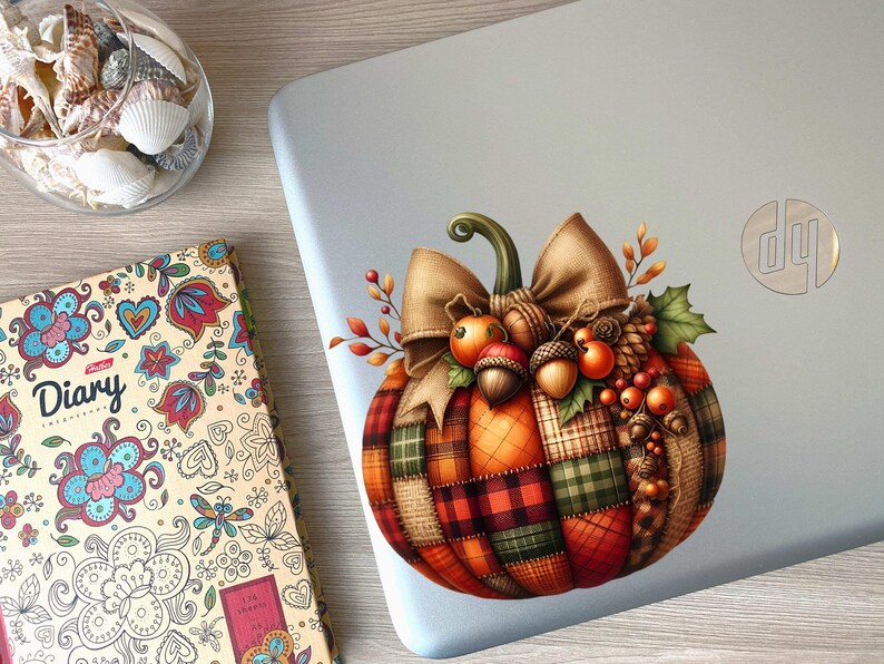 May include: A decorative pumpkin sticker with a plaid design, a brown bow, and autumnal accents like berries and acorns. The sticker is on a silver laptop.