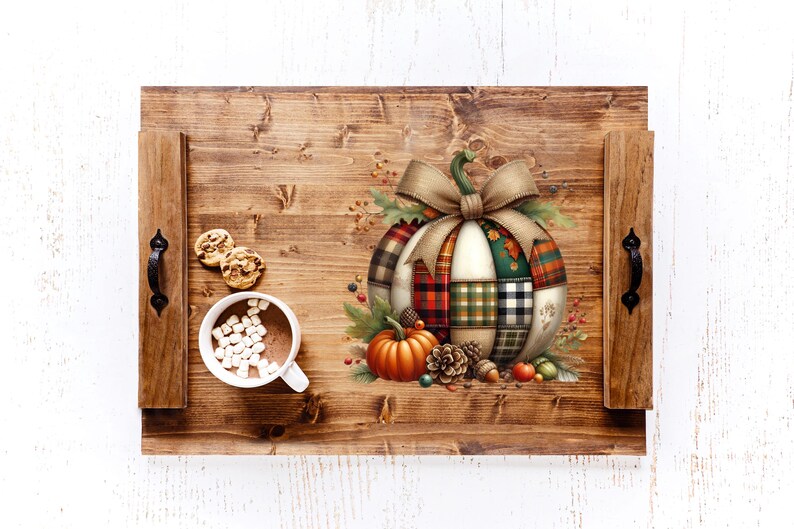 May include: A wooden serving tray with a fall theme. The tray features a decorative pumpkin with a patchwork design, a bow, and autumn foliage. A cup of hot chocolate with marshmallows and cookies are on the tray.