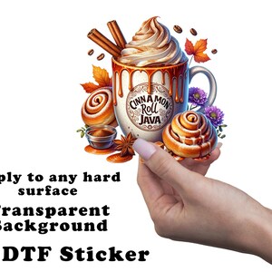 May include: A whimsical sticker featuring a mug of Cinnamon Roll Java, topped with whipped cream and cinnamon sticks. The design includes cinnamon rolls, coffee beans, and fall foliage. The text on the mug reads "Cinnamon Roll Java".