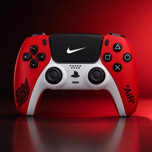 Op de afbeelding: Een rood, wit en zwart draadloze gamecontroller met een wit Nike swoosh-logo op het centrale touchpad, een zwart Air Jordan wings-logo op de linkerhandgreep en de tekst "AIR" in zwarte letters op de rechterhandgreep.