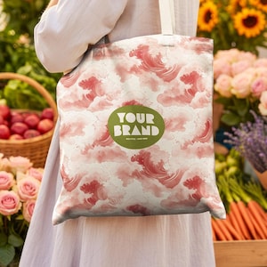 May include: A white tote bag with a repeating pattern of red watercolor wave-like designs. The bag has a green circular logo that says "YOUR BRAND". The bag is being held in front of a market scene with flowers and produce.