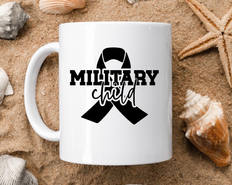 May include: White ceramic mug with a black ribbon and the text "Military child" printed on it.
