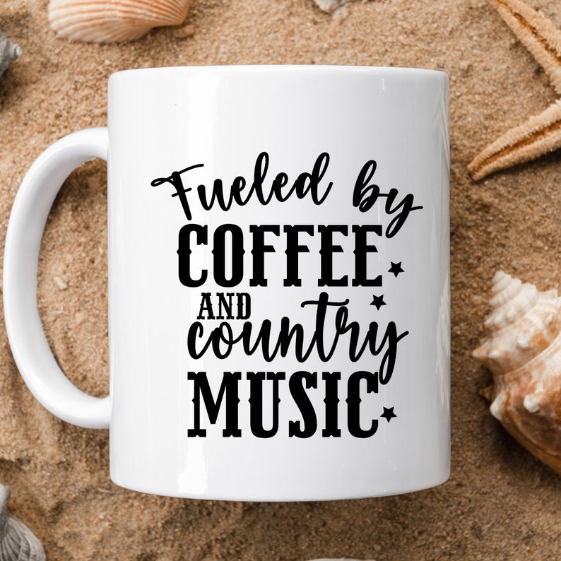 May include: White ceramic coffee mug with black text that reads "Fueled by Coffee and Country Music".