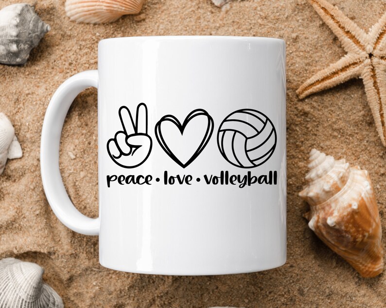 K&ouml;nnte beinhalten: Wei&szlig;e Keramik-Kaffeetasse mit einem schwarzen Peace-Zeichen, einem Herzen und einer Volleyballgrafik. Der Text "peace. love. volleyball" ist unter der Grafik aufgedruckt.