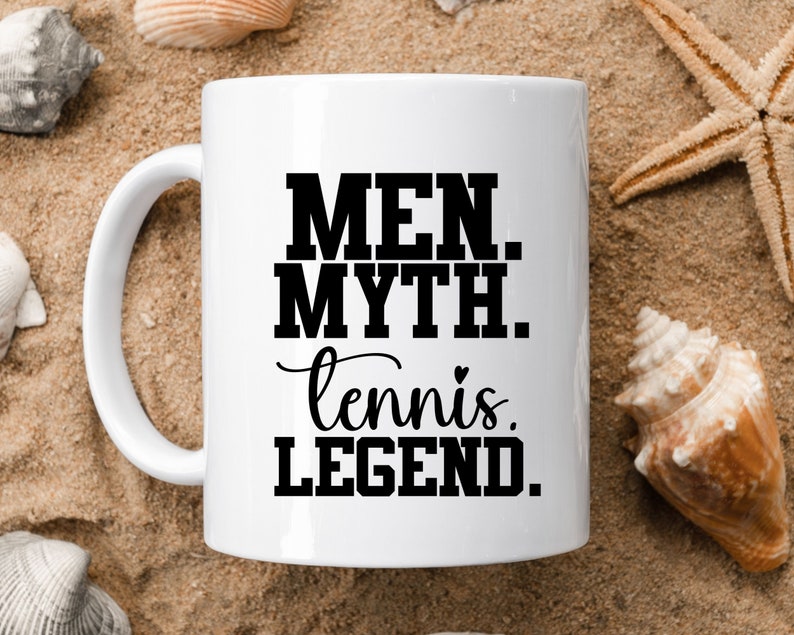 May include: White ceramic coffee mug with black text that reads "Men. Myth. tennis. LEGEND."