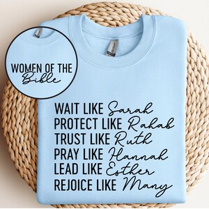 May include: Light blue sweatshirt with black text that reads "Women of the Bible" and "Wait like Sarah, Protect like Rahab, Trust like Ruth, Pray like Hannah, Lead like Esther, Rejoice like Mary."