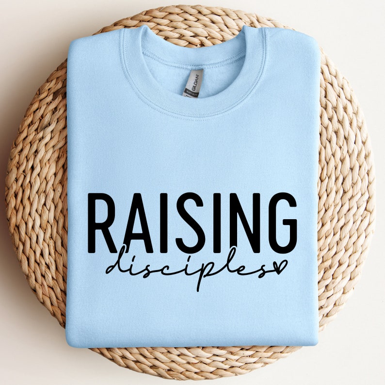 May include: Light blue sweatshirt with the text "RAISING disciples" in black lettering with a small heart.
