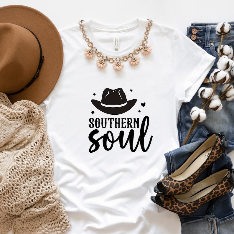 May include: White t-shirt with a black cowboy hat graphic and the text "Southern soul" in black.