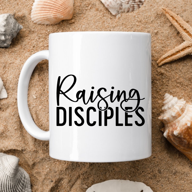 May include: White ceramic coffee mug with black text that reads "Raising Disciples".