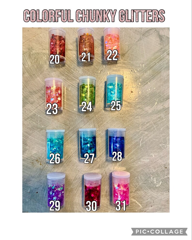 May include: A collection of 11 small jars filled with colorful chunky glitter. The jars are labeled with numbers 20 through 31.