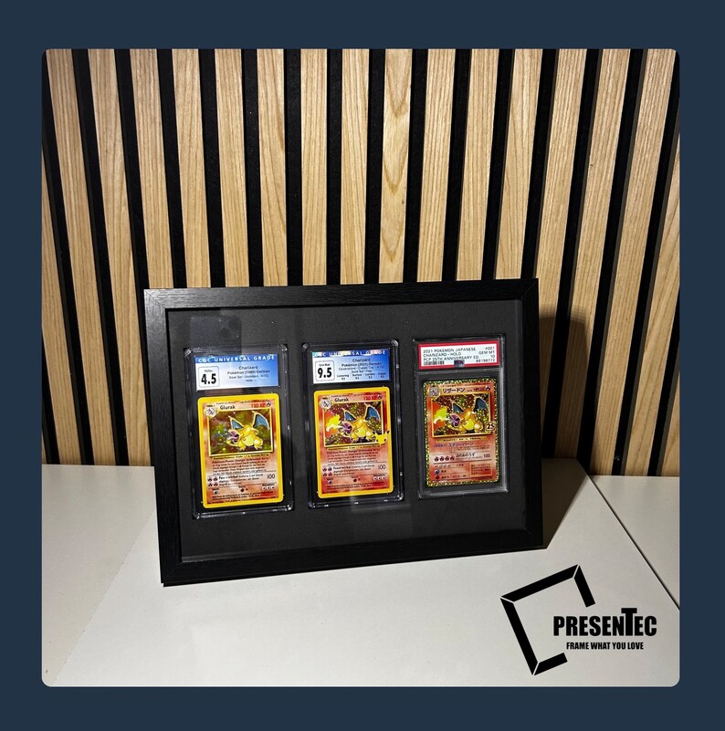 May include: Three Pokemon trading cards are displayed in a black frame with a white mat. The cards are graded 4.5, 9.5, and 9.5. The cards feature the Pokemon Charizard.