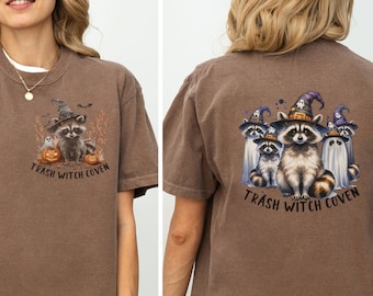 May include: Brown t-shirt with a graphic of raccoons wearing witch hats and the text "Trash Witch Coven" on the front and back.