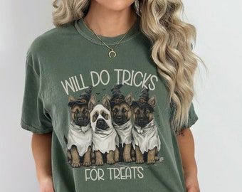 May include: Green t-shirt with a graphic of four German Shepherd puppies dressed in Halloween costumes. The text "Will do tricks for treats" is printed on the shirt.