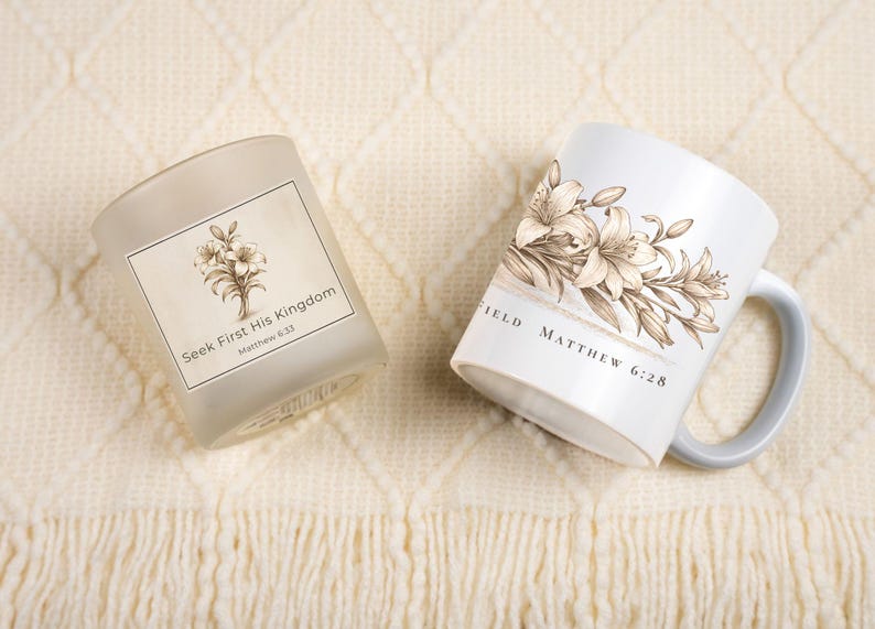 May include: A white ceramic mug and a frosted glass candle holder with floral designs. The mug has a gray handle and the text "Matthew 6:28". The candle holder has the text "Seek First His Kingdom Matthew 6:33".