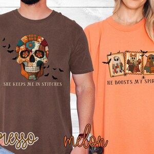 May include: Two t-shirts, one espresso brown and one melon orange. The brown shirt features a colorful skull design with the text "She keeps me in stitches." The orange shirt displays three ghost-like figures with the text "He boosts my spirits."
