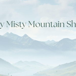 May include: The image features a serene mountain landscape with a misty atmosphere. The text "My Misty Mountain Shop" is displayed in elegant, dark green lettering against the backdrop of the mountains and sky.