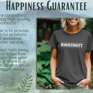 May include: Dark gray t-shirt with the text "NIGHTSHIFT" in white, with additional text below. The shirt is worn by a person. The background includes text about a happiness guarantee.