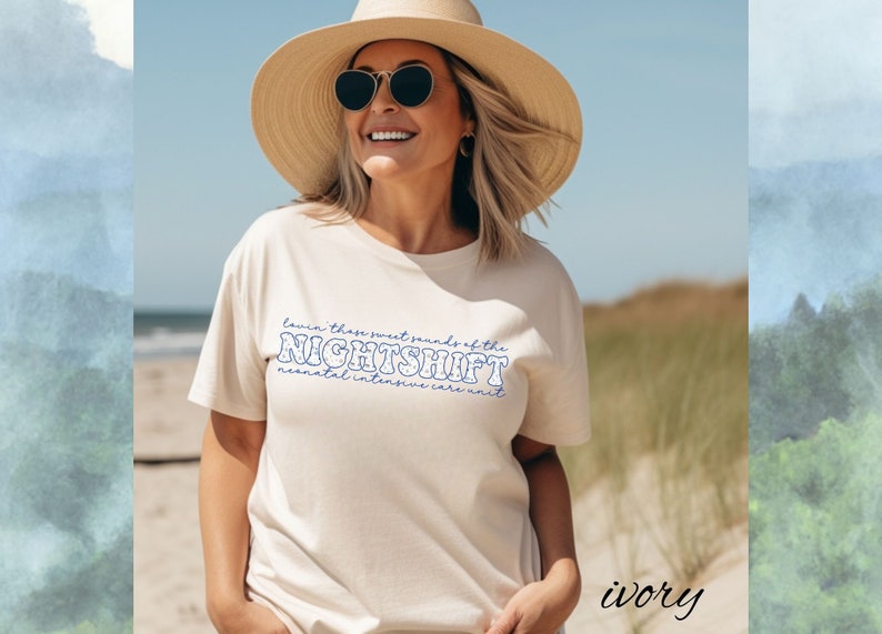 May include: Ivory-colored t-shirt with the text "Lovin' these sweet sounds of the NIGHTSHIFT neonatal intensive care unit" in blue. The person in the image is wearing a straw hat and sunglasses.