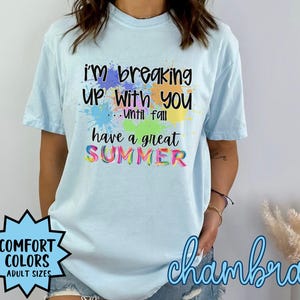May include: Light blue t-shirt with the text "i'm breaking up with you...until fall have a great SUMMER" in rainbow colors. The shirt is available in adult sizes and comes in a variety of colors.