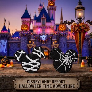 May include: Two black embroidered patches shaped like Mickey Mouse ears. One patch features white fabric strips resembling a mummy wrap, while the other displays a white spiderweb design. A sign below reads DISNEYLAND RESORT HALLOWEEN TIME ADVENTURE.