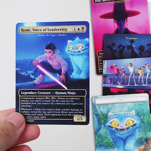 May include: A collection of fantasy trading cards. The primary card features a ninja with a glowing sword and a blue cat-like creature. Other cards show various illustrations, including a figure in a wide-brimmed hat and a group of animated characters. The text "Rumi, Voice of Leadership" is visible.