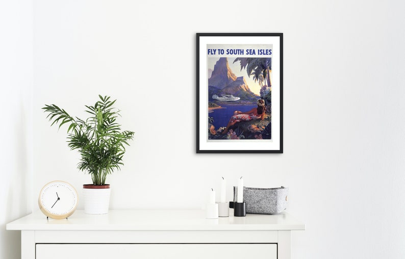 May include: Vintage travel poster advertising a trip to the South Sea Islands. The poster features a colorful illustration of a tropical island with a mountain, palm trees, a woman in a grass skirt, and a seaplane flying overhead. The text "Fly to South Sea Isles" is printed in blue at the top of the poster.