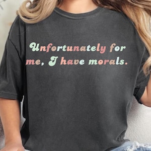 May include: A black t-shirt with the text "Unfortunately for me, I have morals." printed in pink, green, and light blue.