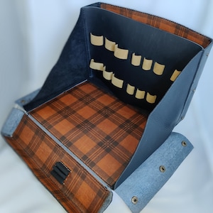 May include: A blue leather box with a brown plaid lining and multiple pockets inside. The box has a flap that closes with a snap.