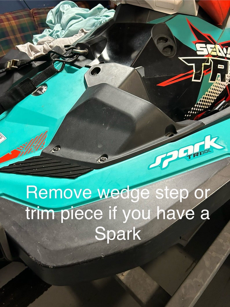 May include: A close-up of a turquoise and black Sea-Doo Spark watercraft. The watercraft has a black and red Sea-Doo logo and the words 'Spark TRIXX' on the side. The text 'Remove wedge step or trim piece if you have a Spark' is visible in the image.