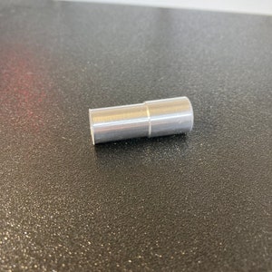 Puede incluir: Un tubo de metal plateado con una costura ligeramente elevada en el medio.