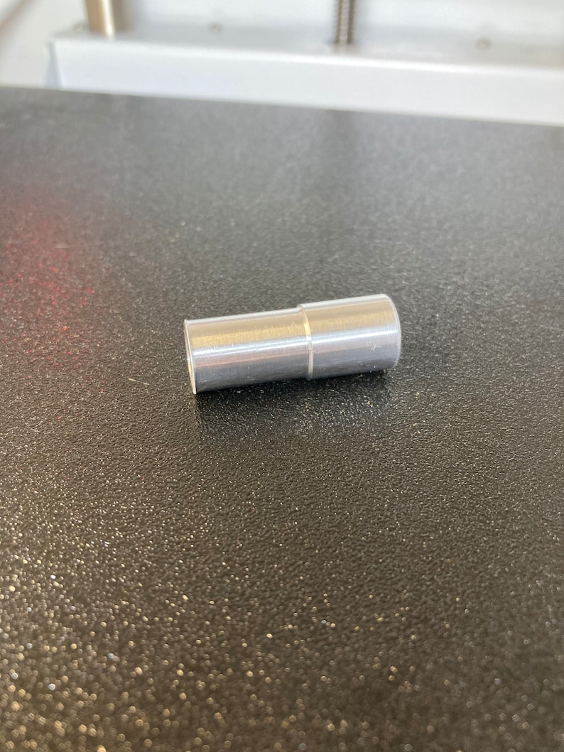 Puede incluir: Un tubo de metal plateado con una costura ligeramente elevada en el medio.