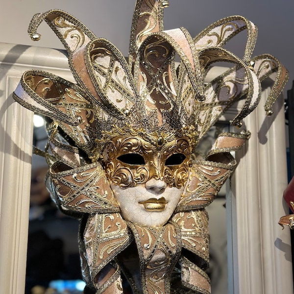 Venezianische Narrenmaske aus goldenem Samt. Tragbare Maske und Heimdekorationsmaske.