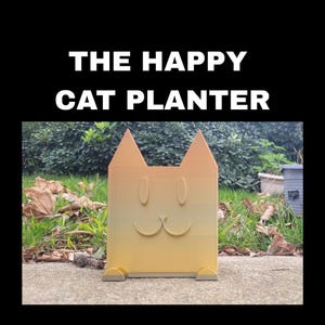 May include: A cat-shaped planter with a smiling face, made of orange and yellow gradient material. The planter has pointed ears and a rectangular body. The text "THE HAPPY CAT PLANTER" is displayed above the planter.