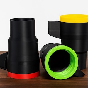 Peut inclure: Trois tasses de voyage noires avec des accents colorés. L'une a une base rouge, une autre un couvercle jaune et la troisième un bord vert. Chaque tasse a une poignée et un design cylindrique unique.