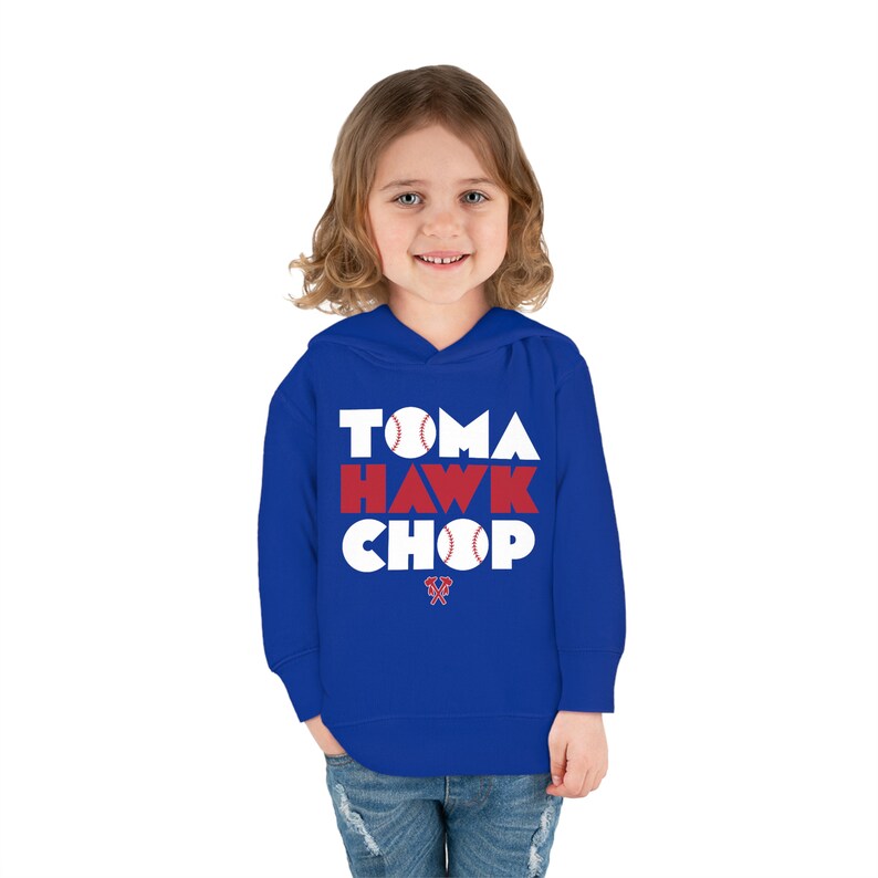 May include: A royal blue hooded sweatshirt with white text that reads "TOMAHAWK CHOP" with a baseball graphic in each letter. The text is in a bold, blocky font.