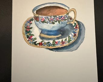 May include: A watercolor painting of a teacup and saucer. The teacup is blue with a floral pattern and filled with brown tea. The saucer is white with a floral pattern.