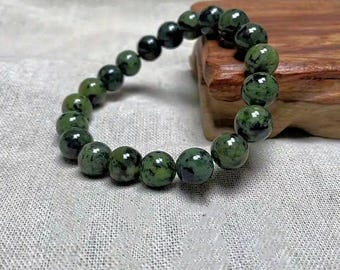 May include: A green and black speckled stone bracelet with round beads.