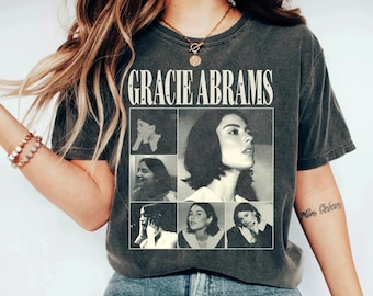 Puede incluir: Una camiseta gris antracita con un gráfico de estilo vintage de Gracie Abrams. El gráfico presenta un collage de fotos en blanco y negro de Abrams.