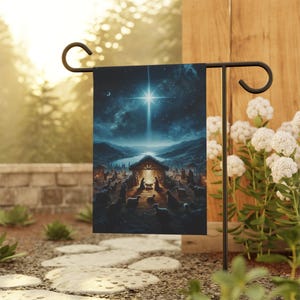 Könnte beinhalten: Eine Weihnachtsgartenflagge mit einem blauen Nachthimmel, einem hellen Stern und einer Krippe mit einem Stall, Maria, Josef und dem Jesuskind. Die Szene ist von Schafen und Hirten umgeben.