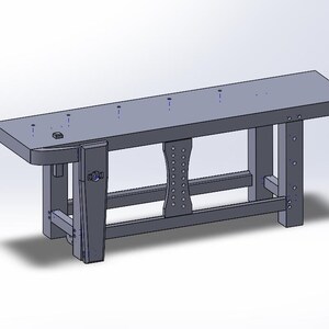 May include: A grey wooden workbench with a vice and a shelf. The workbench has a rectangular top with a series of holes drilled into it.