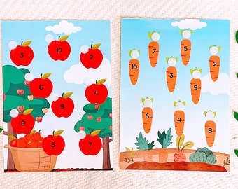 May include: Two colorful educational game boards with red apples and orange carrots. The boards have numbers 1-10 on them. There are also green leaves and white circles on the boards.