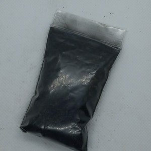Puede incluir: Una pequeña bolsa de plástico llena de polvo negro.
