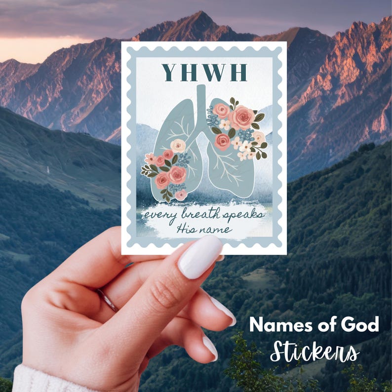 May include: A sticker featuring a light blue illustration of lungs adorned with pink and white flowers. The sticker has the text "YHWN" at the top and "every breath speaks His name" at the bottom. The sticker is held in a hand against a mountain backdrop.