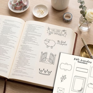 May include: A Bible journaling traceables sheet featuring black line art illustrations including a sheep, a crown, gates, and the text The Lord is My Shepherd. The sheet includes various decorative frames, floral accents, and an envelope design.