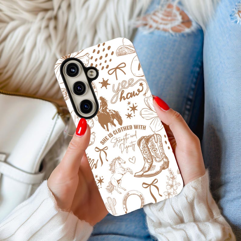 May include: White phone case with a brown and white western-themed design. The design includes a horse, cowboy boots, a horseshoe, a cactus, and the text "yee haw" and "She is clothed with strength and dignity".